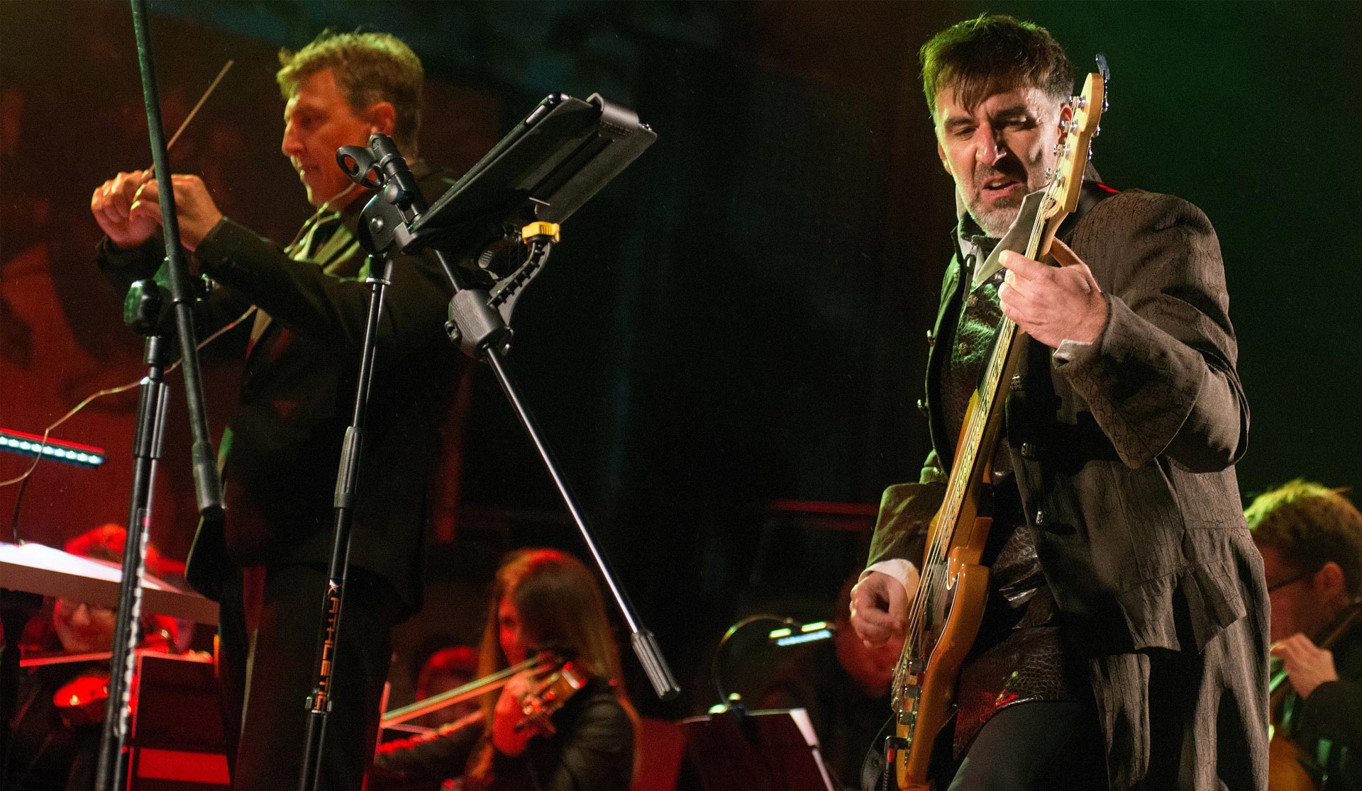 Zdjęcie tytułowe przedstawia dwóch muzyków na scenie. Gitarzystę i