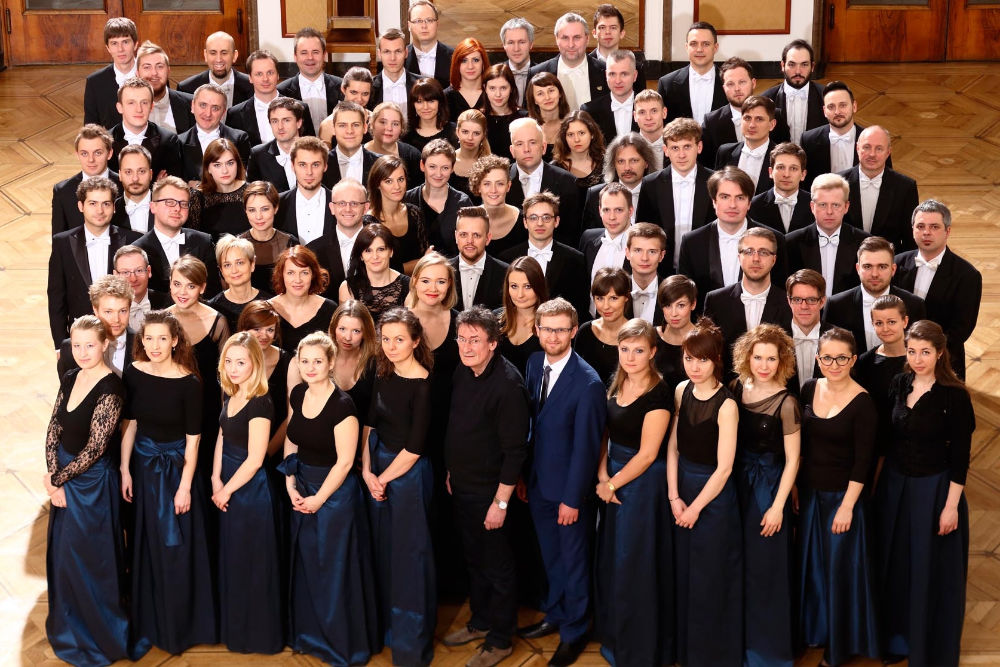 Na zdjęciu muzycy Orkiestry Akademii Beethowenowskiej pozujący w grupie w pozycji stojącej. Młodzi – kobiety i mężczyźni w eleganckich strojach. Czarne smokingi i bluzki i granatowe spódnice.